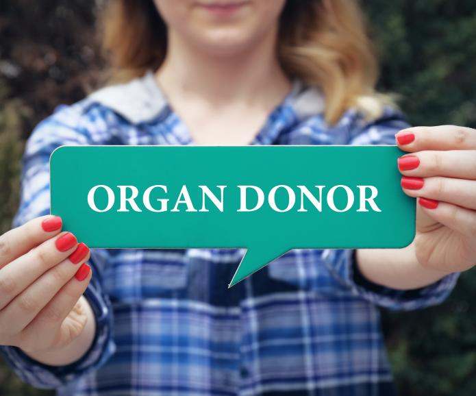 woman holding organ donor sign