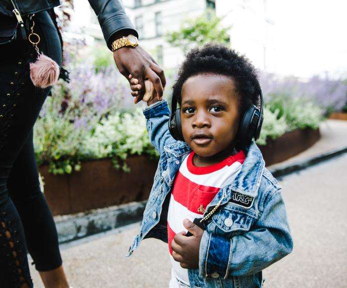 young black boy walking with mom headphones TONL 009238