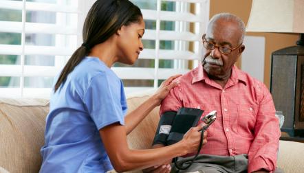 caregiver taking blood pressure black senior