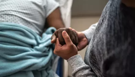 Hospital patient holding hands with a visitor