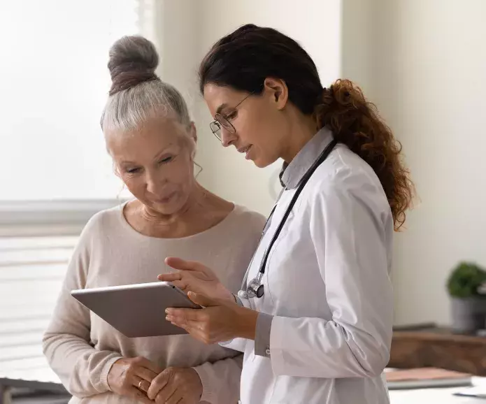 Doctor reviewing information on a tablet with a woman