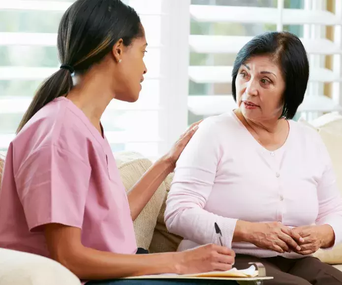 An African American nurse talking to Hispanic patient