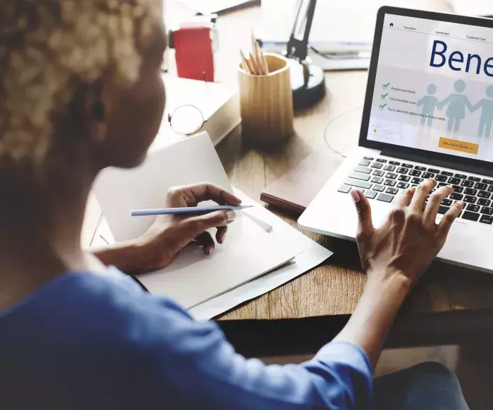 An African American woman choosing health insurance coverage on a laptop