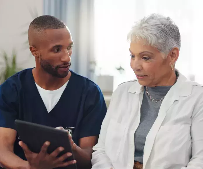 A nurse talking to an elderly patient