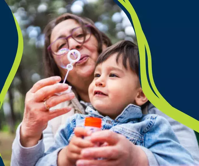 Woman blowing bubbles with child