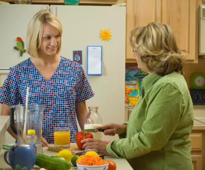 nurse with senior in kitchen