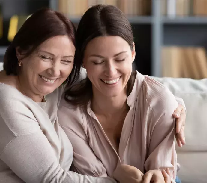 white mom adult daughter hug on couch white mom adult daughter hug on couch