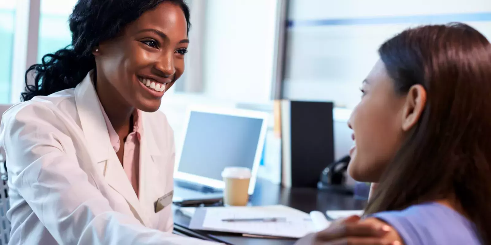 black doctor touching patient shoulder