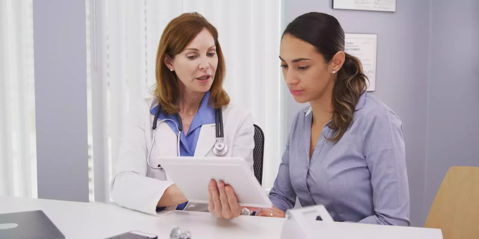 doctor reviewing charts with woman doctor reviewing charts with woman