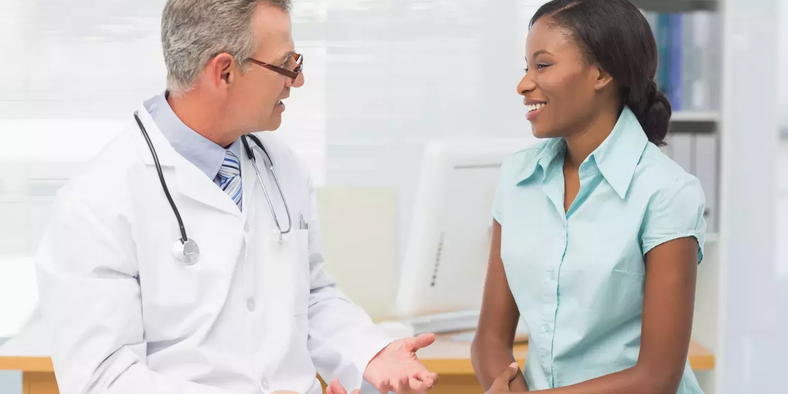 white doctor black patient talking