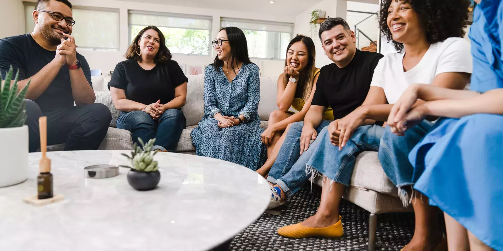 A diverse group of friends sitting around a living room table