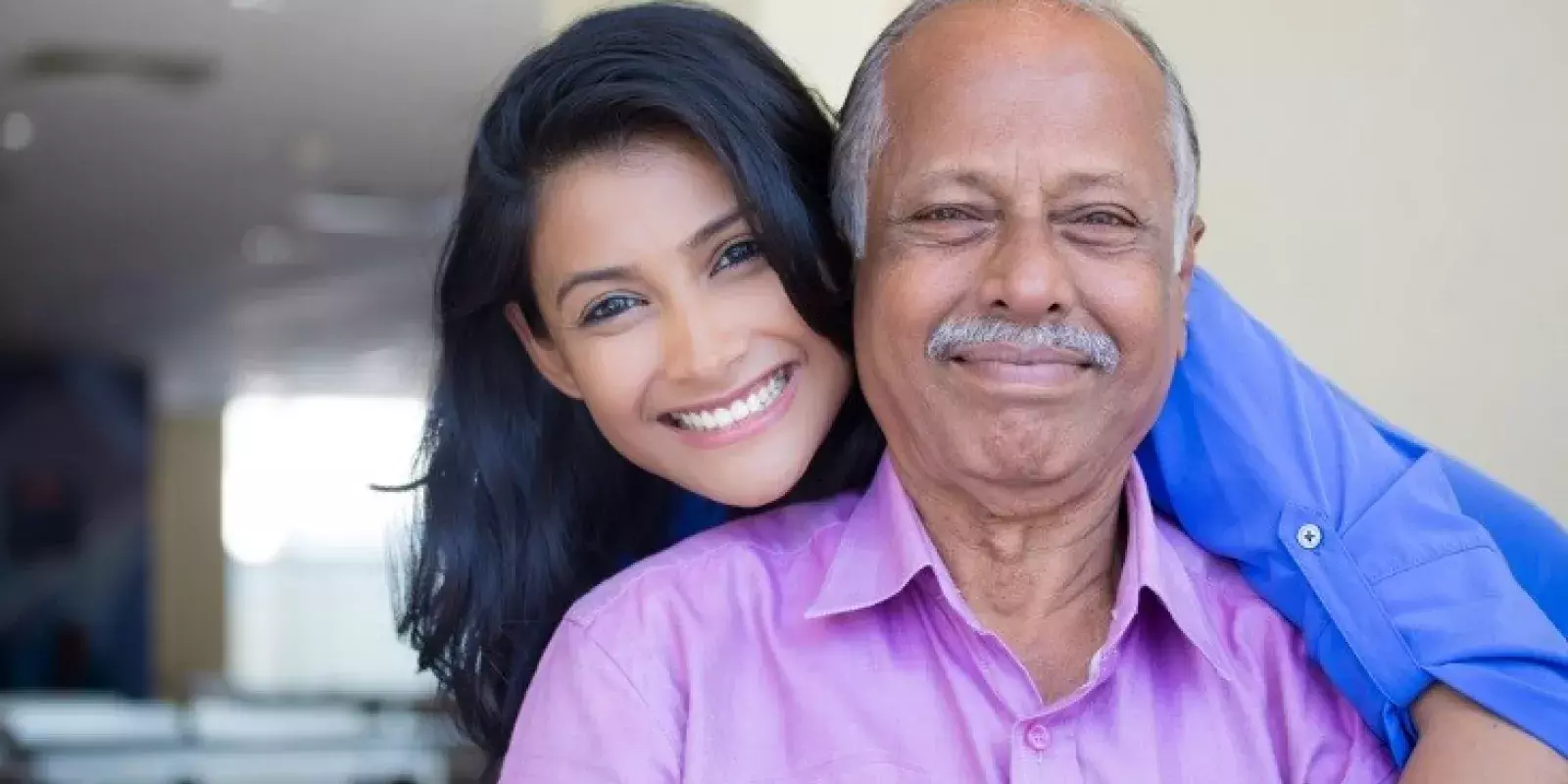 young woman hugging senior man